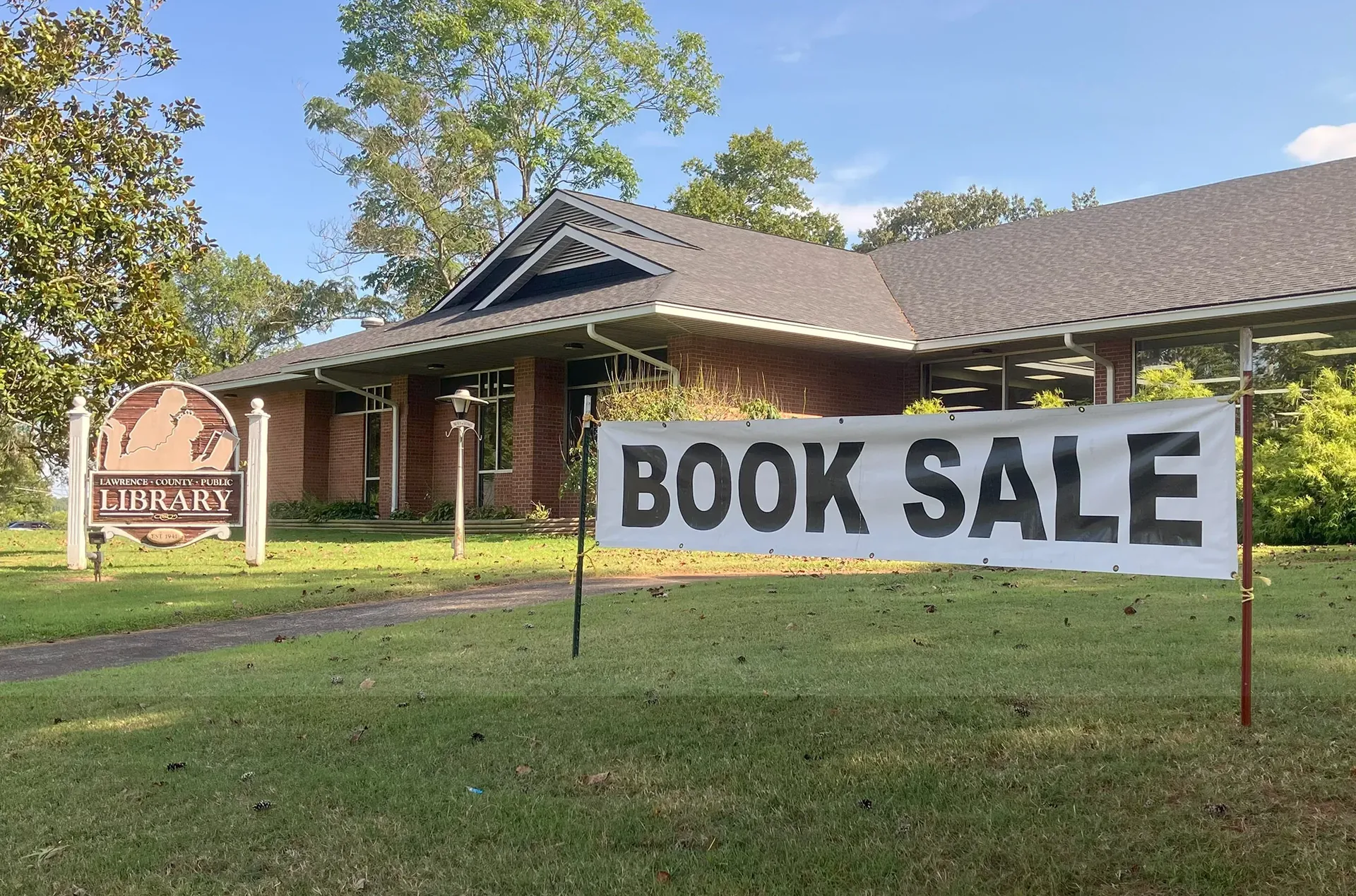 A Book Sale sign on the lawn in front of the Lawrenceburg library