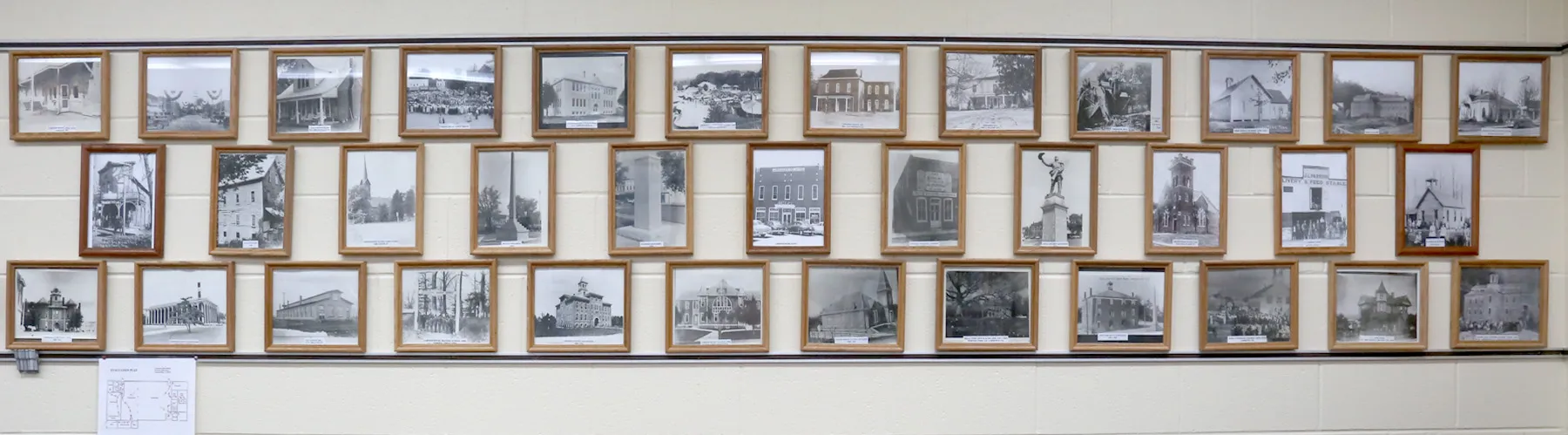 A wall of framed historical photographs of Lawrence County