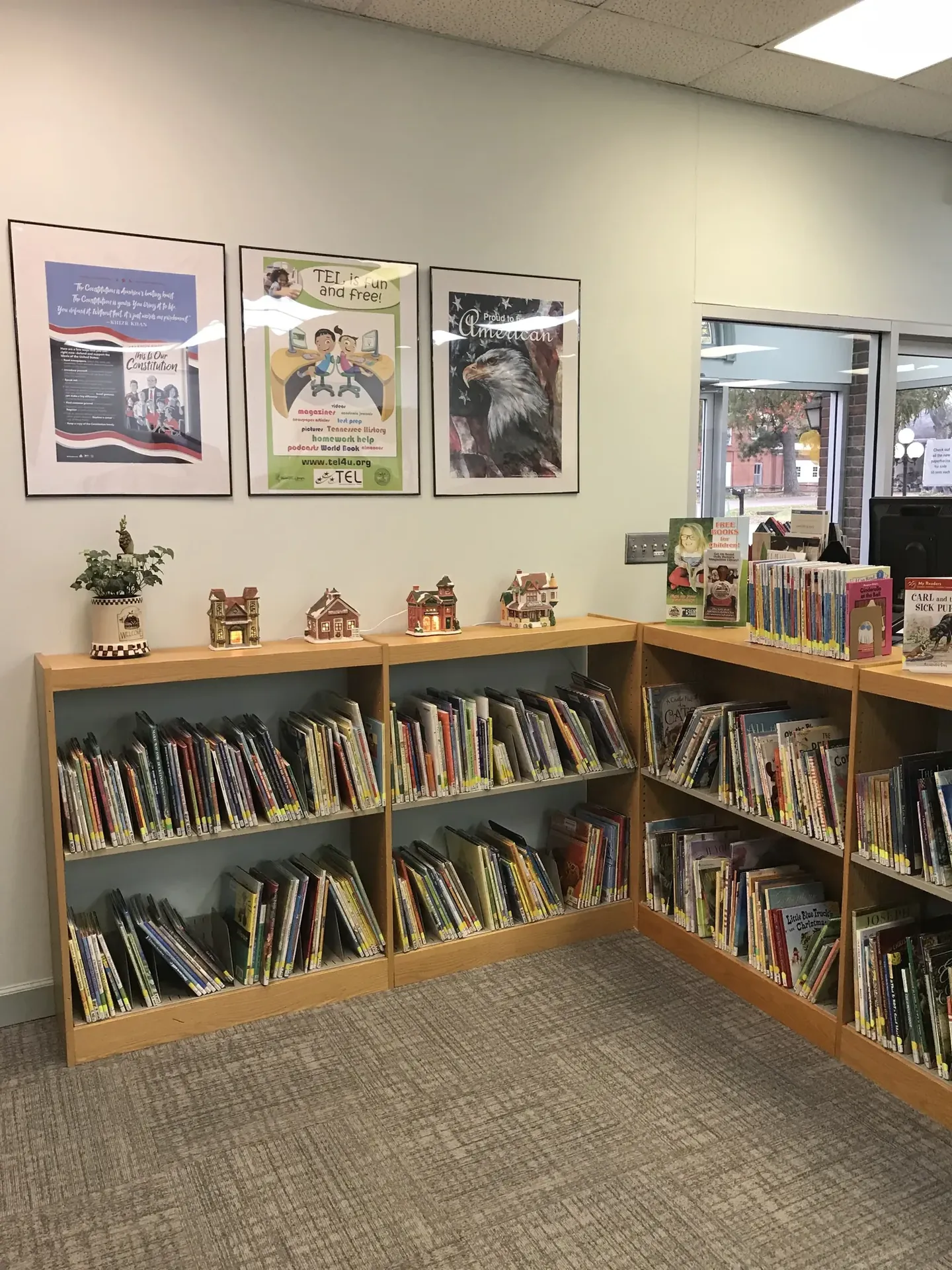 Estanterías en una esquina bajo obras de arte enmarcadas en la biblioteca de Loretto